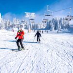 Menschen genießen Skifahren und Snowboarden im Bergskigebiet mit wunderschöner Winterlandschaft im Hintergrund