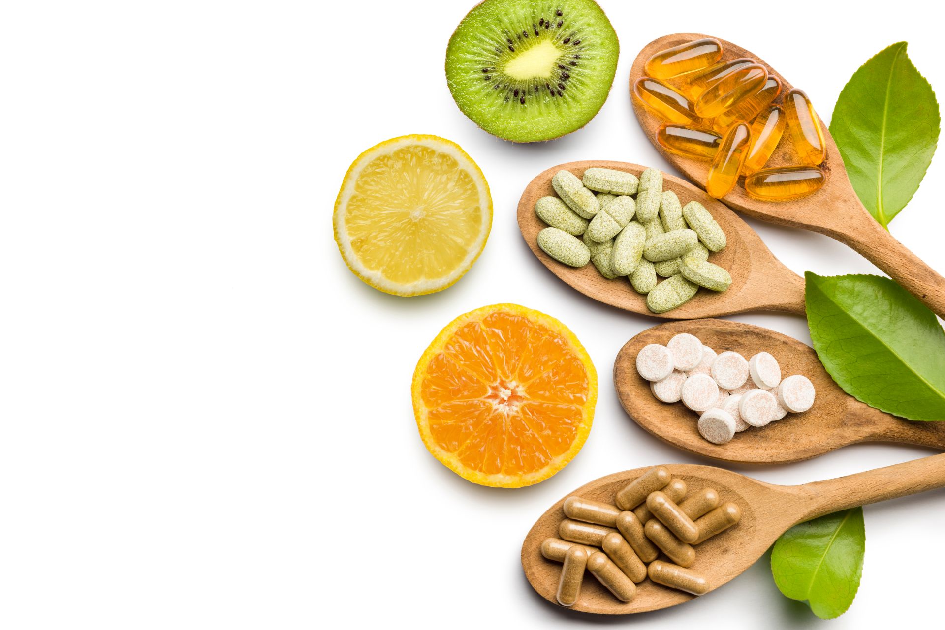 Verschiedene Nahrungsergänzungsmittel und Vitamine in Holzlöffeln, begleitet von frischen Früchten, symbolisieren die Unterstützung der Gesundheit durch SAM-e.