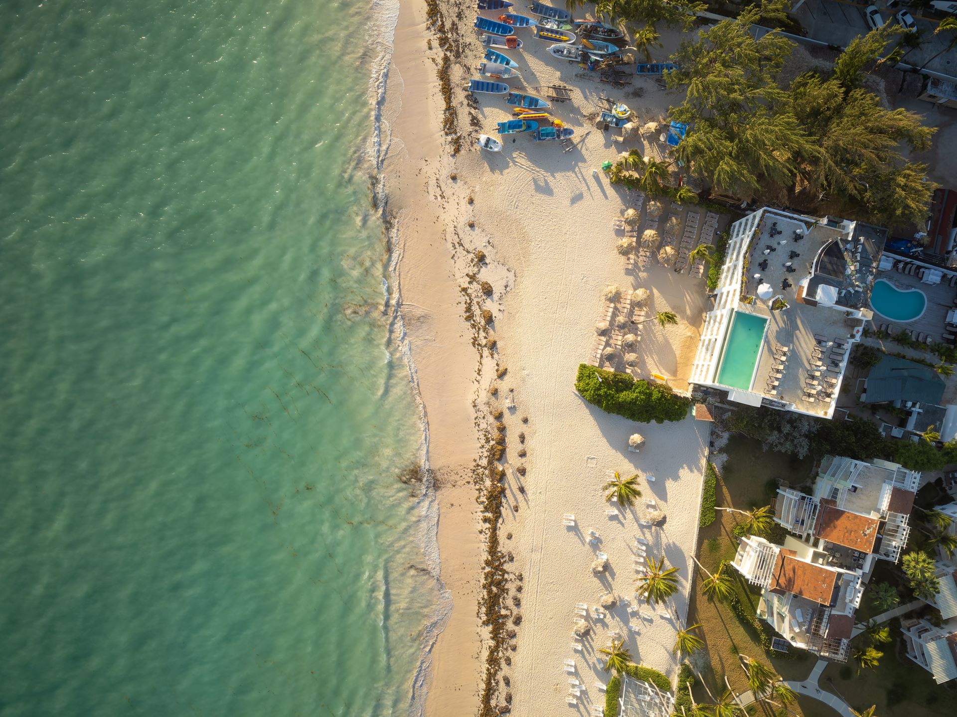 Luftaufnahme von Strandvillen und türkisfarbenem Meer in Dubai.