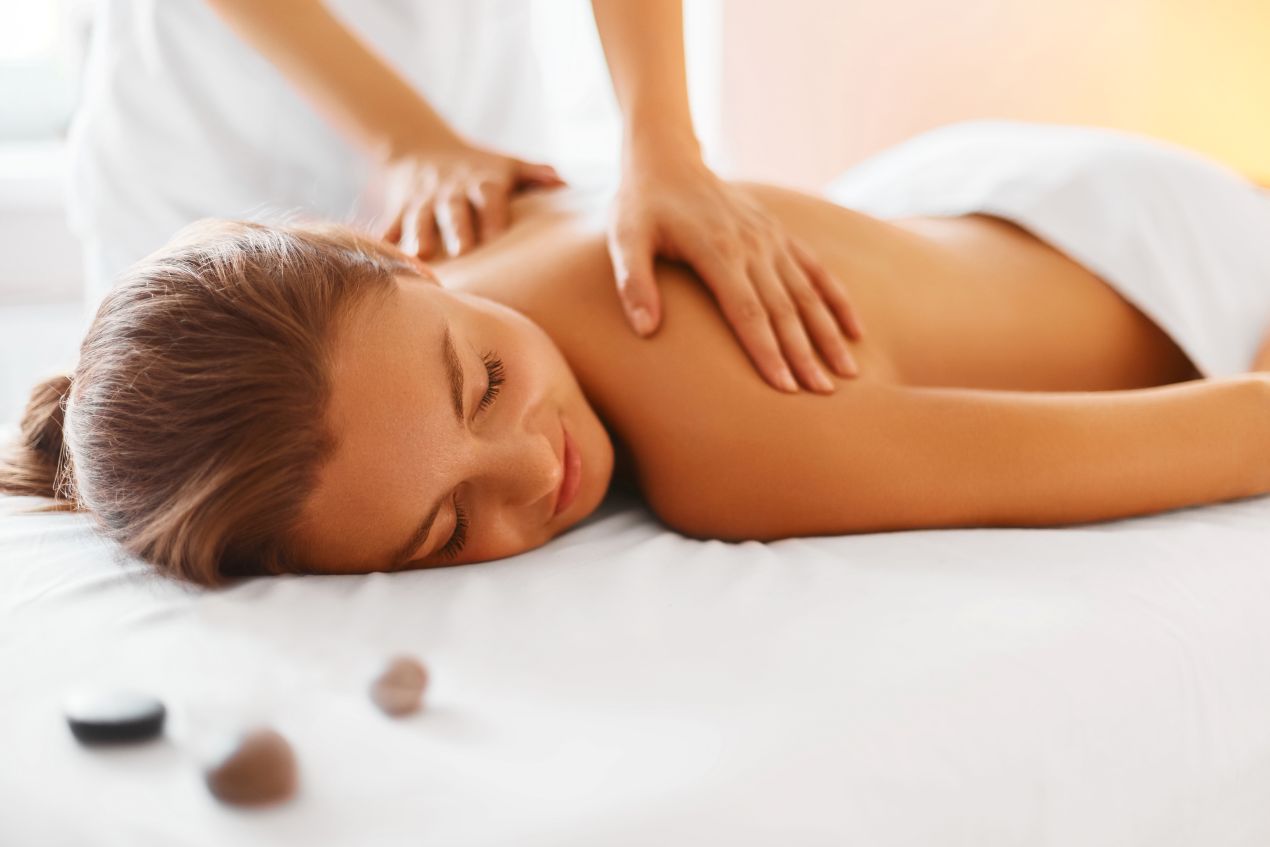 Rueckenmassage fuer eine Frau im Spa-Bereich eines Wellnesshotel 4 Sterne