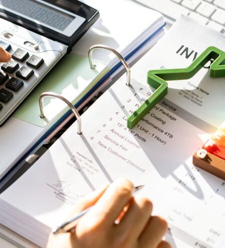 Energieberater Ausbildung: Mann mit Taschenrechner berechnet Kosten und Energieeffizienz anhand von Unterlagen und Diagramm