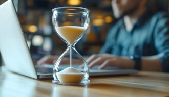 Sanduhr auf Schreibtisch vor Laptop | AMZ Agentur